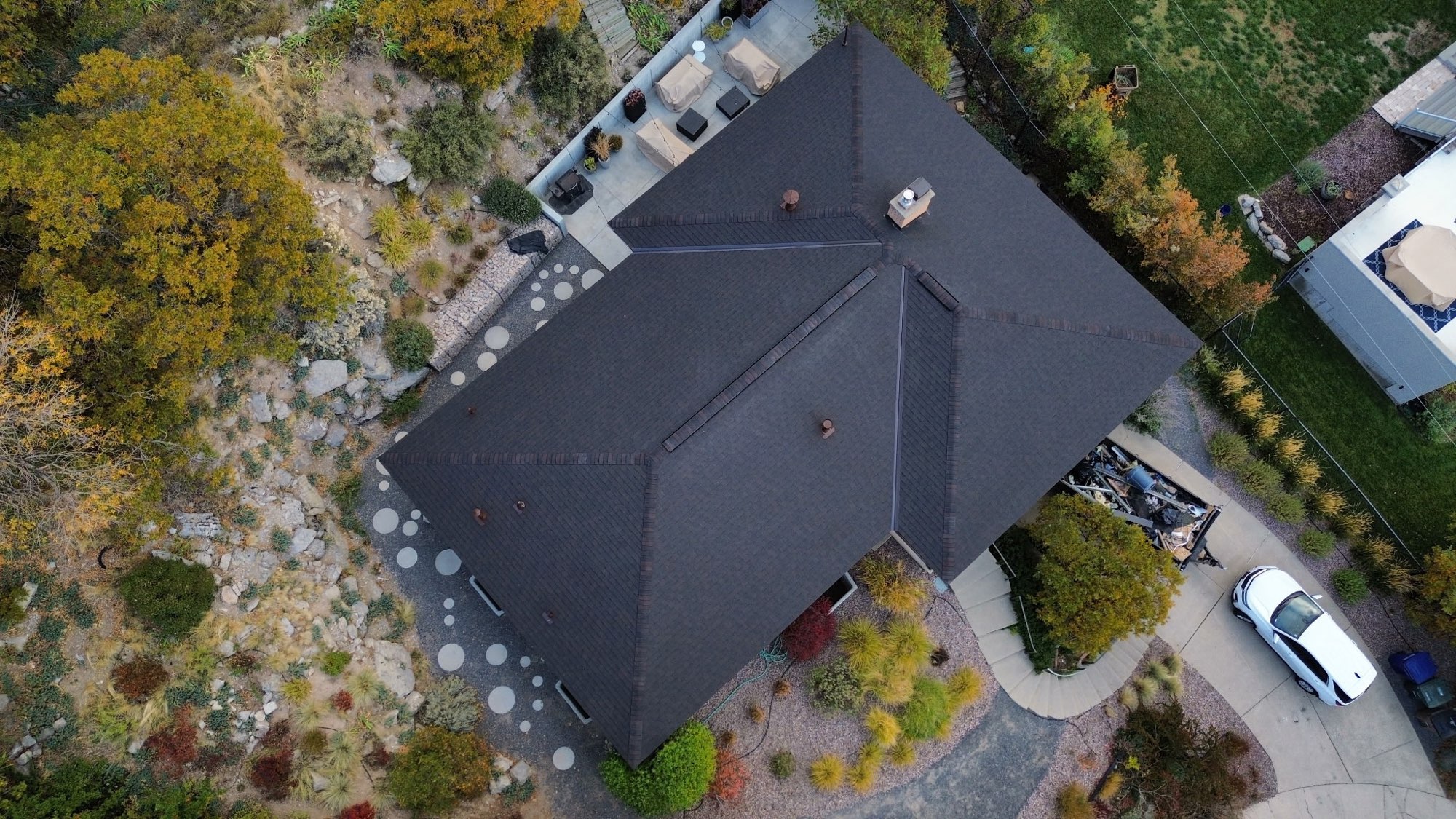 Aerial view of a completed charcoal architectural shingle roof on a Utah hillside home
