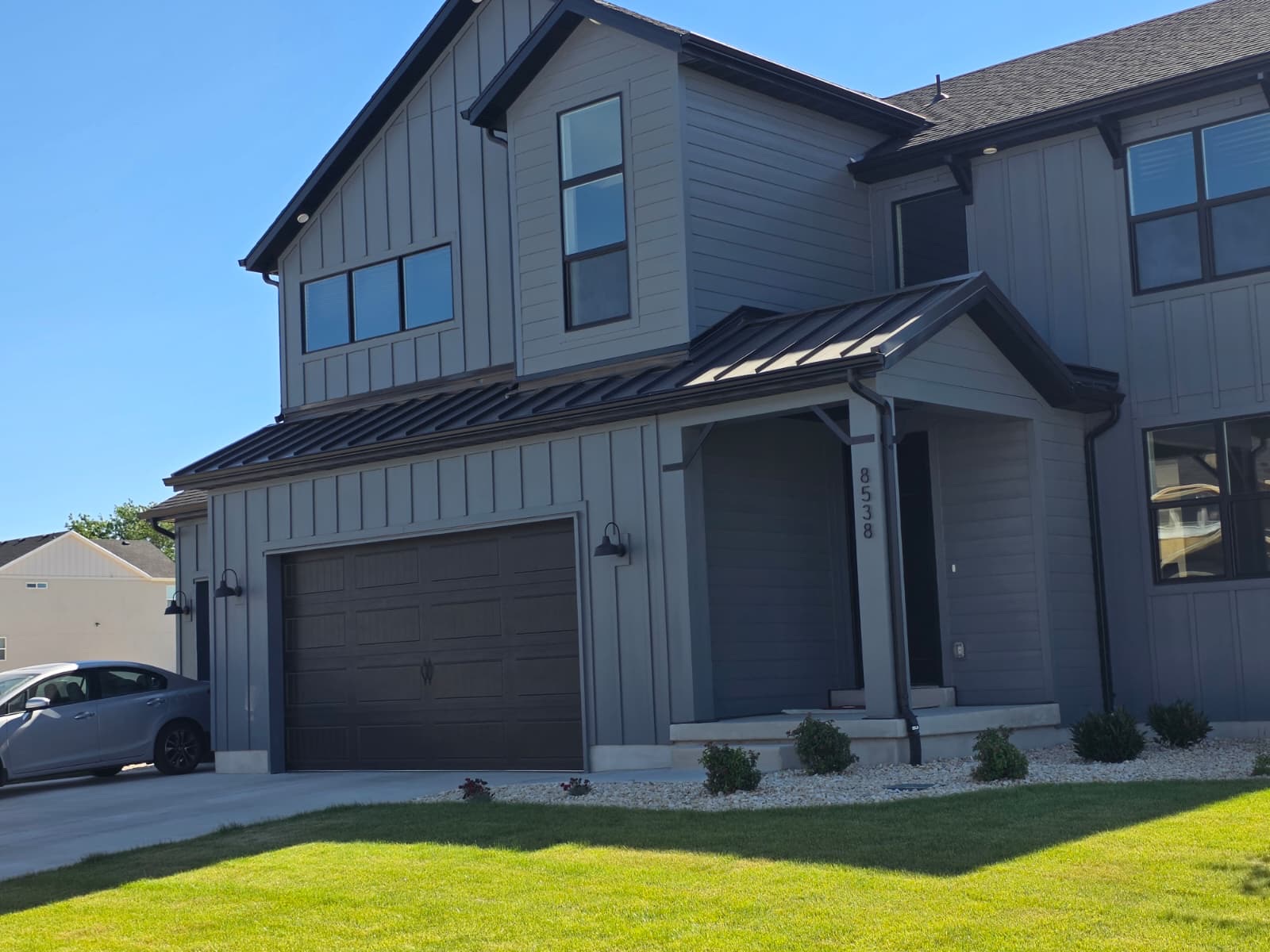 Modern farmhouse with dark metal accent roofing and trim in Utah